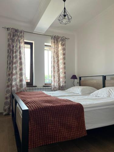 a bedroom with two beds and two windows at Green Agarak Guest House near Dendropark, Stepanavan in Gyulagarak