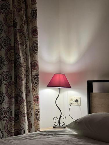 a red lamp sitting next to a bed at Green Agarak Guest House near Dendropark, Stepanavan in Gyulagarak
