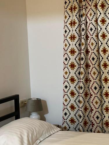 a bedroom with a bed and a wall with a patterned curtain at Green Agarak Guest House near Dendropark, Stepanavan in Gyulagarak