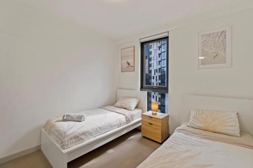 a bedroom with two beds and a window at Southbank Apartment with Skyline View: 5-Min Walk to CROWN Casino in Melbourne