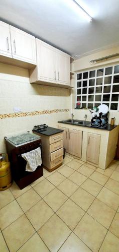 a kitchen with a sink and a stove in it at Tai Homes in Eldoret