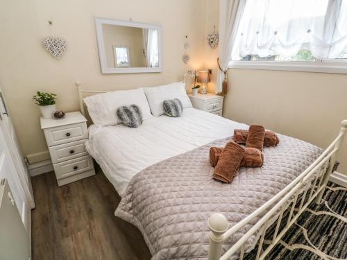 a bedroom with a white bed with towels on it at Villa No 50 in Lanteglos