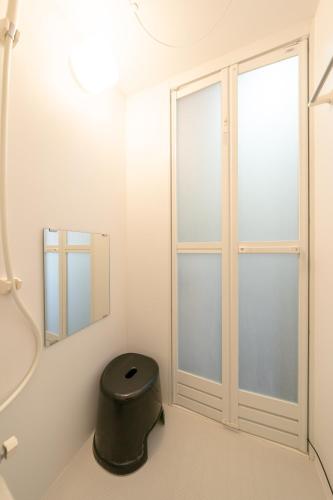a bathroom with a stool and a window at CH Maezato in Ishigaki Island