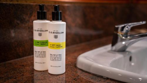 two bottles of sunscreen sitting next to a sink at Pullman Cairns International in Cairns