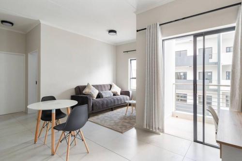 a living room with a couch and a table and chairs at The Blissful Abode by BK Hospitable in Midrand