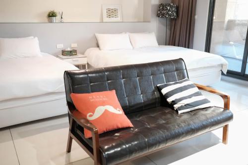 台南市にあるHuzi Roomのベッドルーム(黒い革張りのソファ、ベッド1台付)