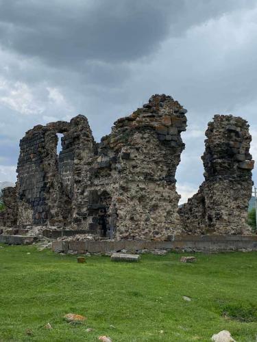 an old stone building in a field of grass at Green Agarak Guest House near Dendropark, Stepanavan in Gyulagarak