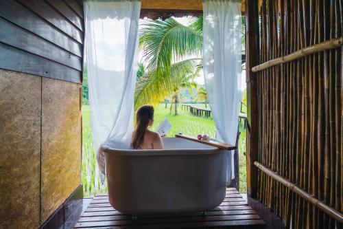 a woman sitting in a bath tub on a porch at Herntai Resort Maelanoi in Ban Mae La Noi