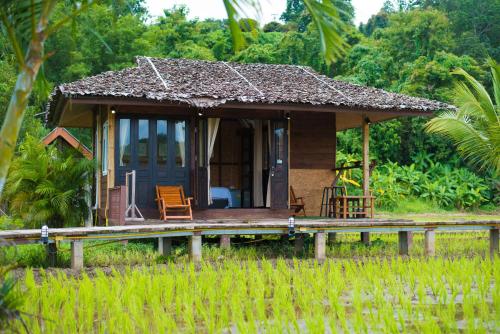 a small house in the middle of a field at Herntai Resort Maelanoi in Ban Mae La Noi
