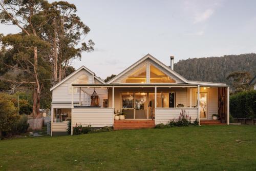 a house with a green lawn in front of it at The Pearl Tasmania in White Beach