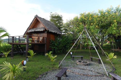 a playground in front of a house with a swing at Herntai Resort Maelanoi in Ban Mae La Noi
