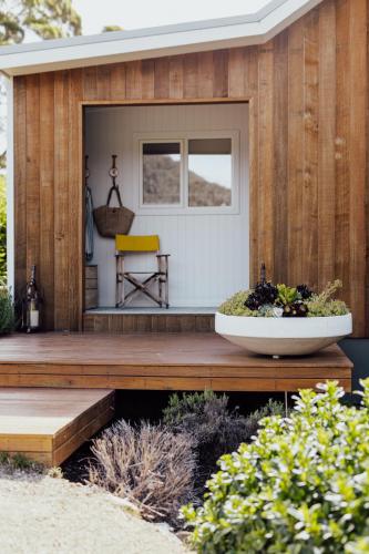 a wooden deck with a yellow chair on it at The Pearl Tasmania in White Beach