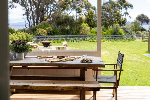 a picnic table and a bench on a patio at The Pearl Tasmania in White Beach