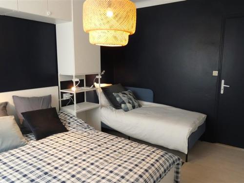 une chambre avec deux lits et un lustre dans l'établissement Appartement Moderne 2 Ch. - Proche Plage - Box WiFi - Tout Confort - FR-1-323-280, à Saint-Jean-de-Monts