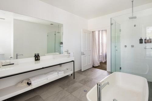 uma casa de banho branca com uma banheira e um lavatório em The Stirling Hotel em Stirling