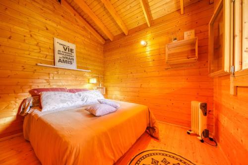 una camera da letto con letto in una camera in legno di Le cottage a La Plaine-des-Palmistes