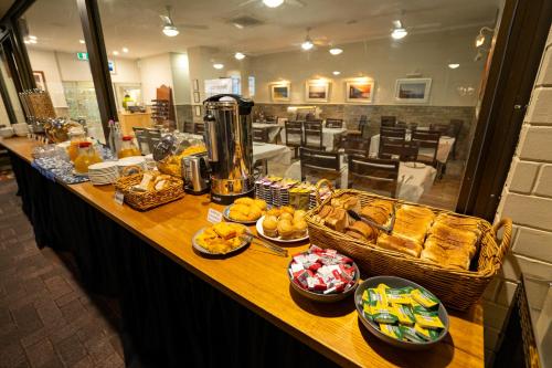 a buffet line with bread and baskets of food at Hospitality Carnarvon, SureStay Collection by Best Western in Carnarvon