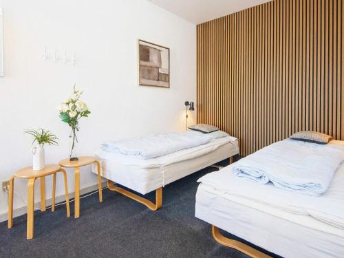 una camera con due letti e un tavolo con fiori di Holiday home Ringkøbing III a Ringkøbing