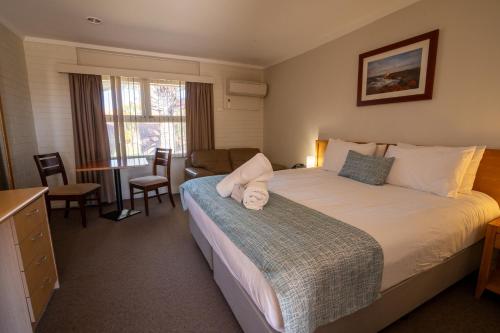 a bedroom with a large bed and a living room at Hospitality Carnarvon, SureStay Collection by Best Western in Carnarvon