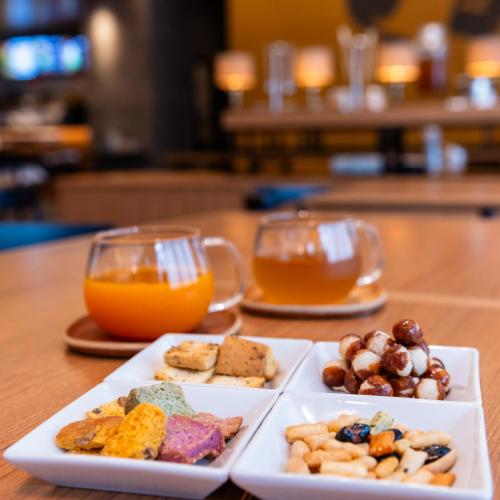 deux assiettes de nourriture et deux verres de jus d'orange dans l'établissement Kobe Hotel Juraku, à Kobe