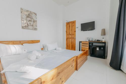 a living room with a bed and a tv at The Marc Vannelli Oslob in Oslob