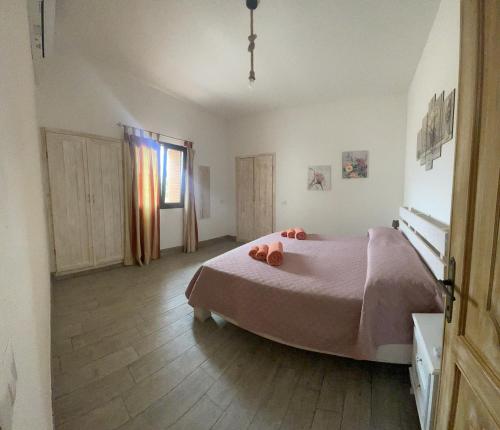 a bedroom with a large bed and a window at S’apposentu in Solinas