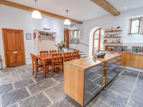 a kitchen and dining room with a wooden table and chairs at The Gatehouse in Sutton in Ashfield