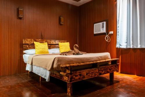 a bedroom with a bed with yellow pillows at Frendz Hostel Boracay in Boracay