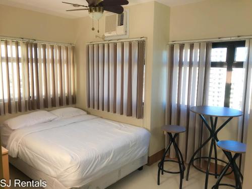 um quarto com uma cama e dois bancos em 2 Bedroom Condo @ Midpoint Residences w/ City View em Mandaue City