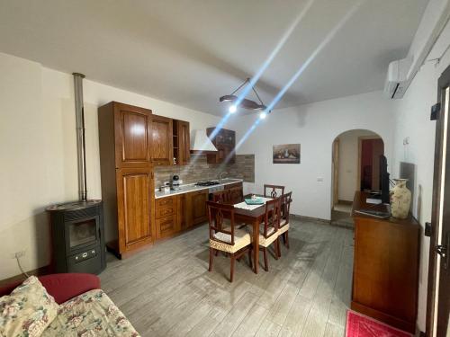 a living room with a table and a kitchen at S’apposentu in Solinas