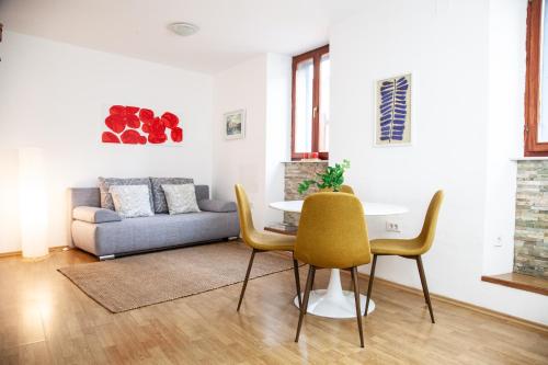 sala de estar con mesa, sillas y sofá en Rosa di Pirano, en Piran