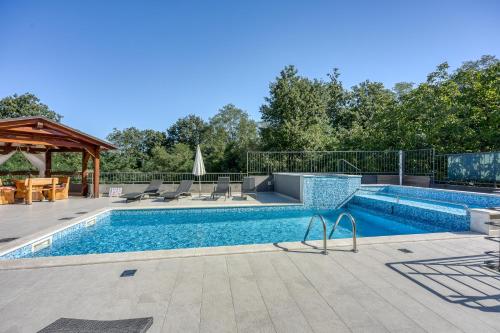 a swimming pool in a yard with a patio at Pool House Klarina - Happy Rentals in Pićan