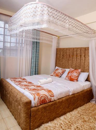 a bedroom with a large bed with a canopy at Zuri Cosy Apartment in Busia