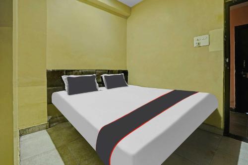 a large white bed in a room with yellow walls at Collection O Hotel Ns Sheetal in Raipur