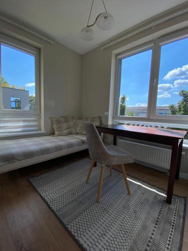 Apartment Fontanu Namai في فيلنيوس: غرفة معيشة مع أريكة ومكتب وكرسي