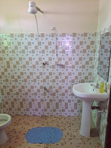 a bathroom with a toilet and a sink and a shower at Zuri Cosy Apartment in Busia