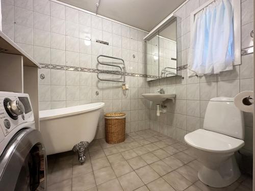 ein Badezimmer mit einer Badewanne, einem WC und einem Waschbecken in der Unterkunft Cozy holiday house near Slite with nice baths in Lärbro