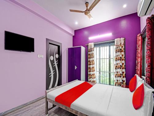 ein Schlafzimmer mit einem Bett und einem TV an der Wand in der Unterkunft Urvashi Guest House in Durgapur
