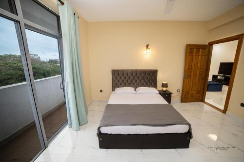 a bedroom with a large bed and a balcony at BNB RESIDENCE MOUNT LAVINIA 1 in Mount Lavinia