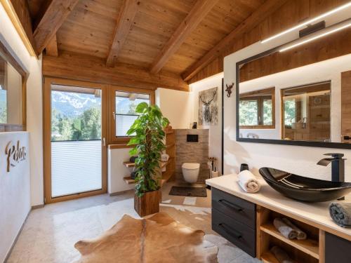 a bathroom with a sink and a mirror at Das Kaiserwohl Chalet in Going