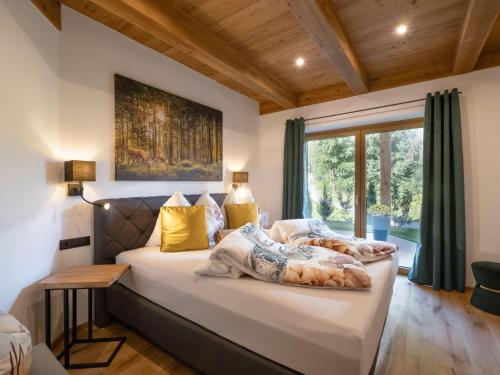 a bedroom with a bed and a large window at Das Kaiserwohl Chalet in Going