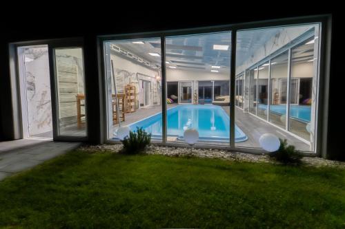 ein Haus mit einem Pool, der durch Fenster gesehen wird in der Unterkunft ŁOSOSINA 365 Dom z basenem 