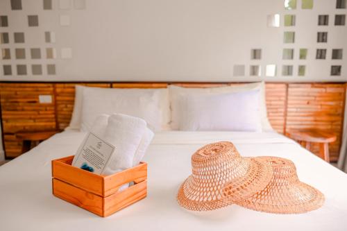 a bed with a box of towels and a hat on it at Escape Life Koh Kood in Ko Kood