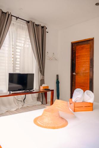 a room with a television and a hat on the floor at Escape Life Koh Kood in Ko Kood