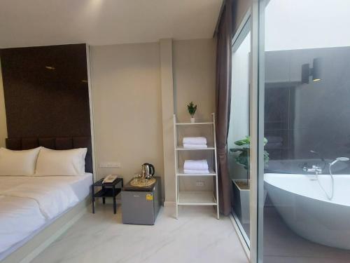 a bedroom with a bed and a bath tub and a sink at KVILLA in Ban Khlong Bang Chak