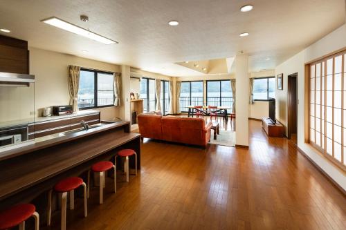 Rakusansui Villa في Itoshima: غرفة معيشة مع أريكة وكراسي حمراء