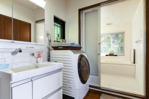 biała pralnia z pralką i umywalką w obiekcie Rakusansui Villa w mieście Itoshima