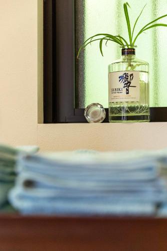 a plant in a glass jar in front of a mirror at Rakusansui Villa in Itoshima