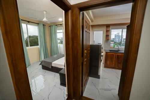 Habitación con cama y cocina con ventanas. en BNB RESIDENCE MOUNT LAVINIA 1, en Mount Lavinia