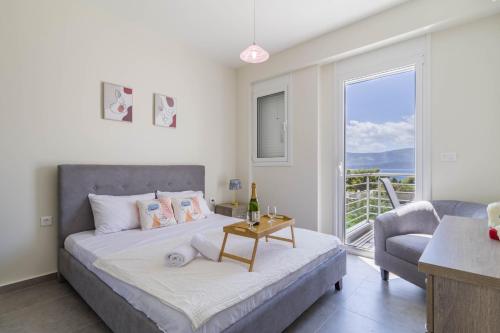 a bedroom with a bed and a living room with a window at Enchanted Sunlit Villa Retreat in Isthmia